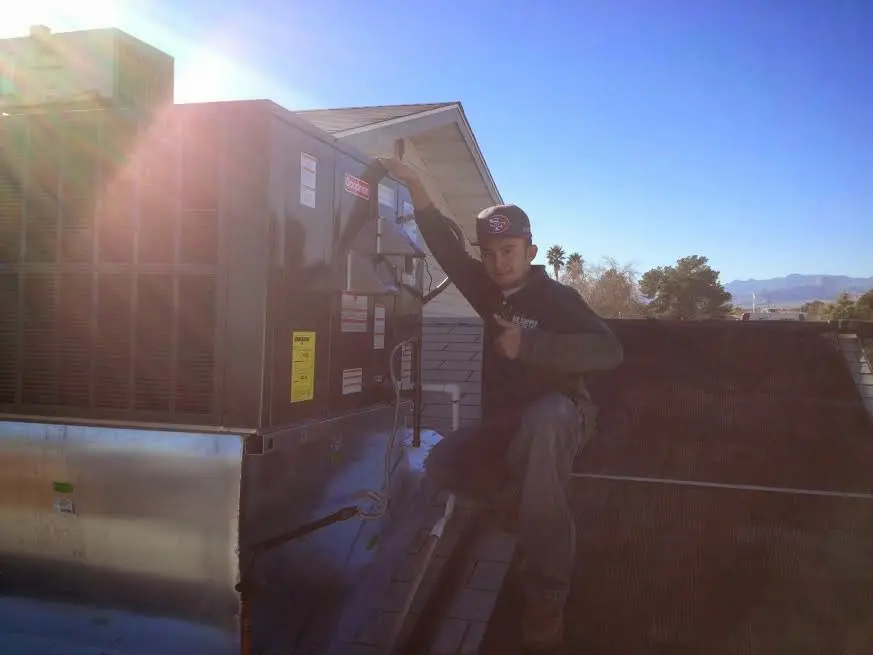 HVAC technician performing Boiler Repair on a rooftop unit in West Orange